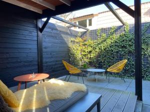 鹿特丹Sfeervol guesthouse, privé tuin en free parking的庭院配有桌椅和桌椅。