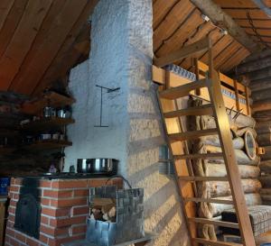 伊纳利Log Cabin - Lord of Sormuset的厨房配有砖炉和墙上的时钟