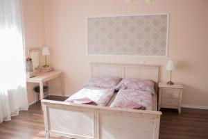 德布勒森Broadway Apartments B3的一间卧室配有一张粉色和白色床单。