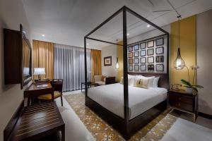 会安Allegro Hoi An . A Little Luxury Hotel & Spa的酒店客房带一张床铺、一张书桌和一间卧室