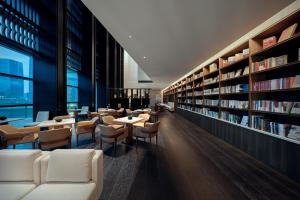深圳深铁前海君璞书院的图书馆配有白色的椅子和桌子以及书架