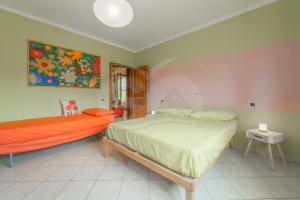 费拉约港A Casa di Zaira - Goelba的卧室配有一张床,墙上挂有绘画作品