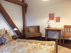 克桑滕豪曼斯霍夫公寓的一间卧室配有一张床、一把椅子和一张桌子