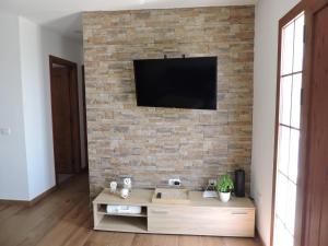 吉亚德伊索拉Arbinfo Casa Rural的一间客厅,在砖墙上配有电视