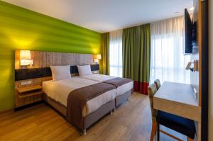 帕彭堡帕彭堡科迪酒店的酒店客房设有一张带绿色墙的床。