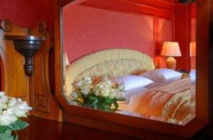 邓弗里斯Mabie House Hotel的镜子中卧室的反射,镜子中的床
