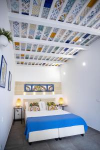 圣维托罗卡波Acquarò Suite Jacuzzi的一间卧室设有一张蓝色和白色天花板的床。