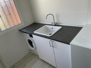 桑卢卡尔-德巴拉梅达Ameyal Casa PIO XII的厨房配有水槽和洗衣机
