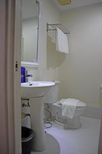 马尼拉奎松市马勒卡费萨尔酒店的白色的浴室设有水槽和卫生间。