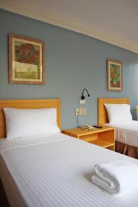 马尼拉奎松市马勒卡费萨尔酒店的酒店客房配有两张床和一张带床铺的书桌