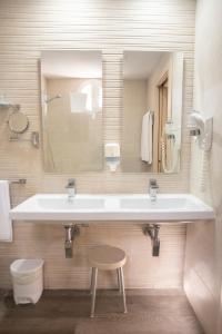 阿尔赫西拉斯阿尔博兰阿尔赫西拉斯酒店的一间带水槽、镜子和凳子的浴室