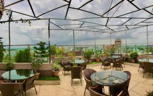 达卡Hotel Shuktara Dhaka的屋顶餐厅,配有桌椅