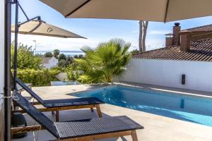 埃勒凡达尔Catalunya Casas Exceptional Villa with sea views only 1800m to beach!的一个带椅子和遮阳伞的游泳池