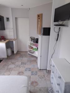 索容LA DATCHA的厨房配有白色冰箱,铺有瓷砖地板。