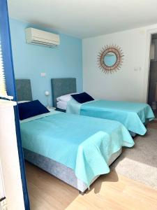 杜布罗夫尼克Madonna Guesthouse II的蓝色墙壁客房的两张床