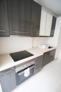 里斯本Oriente DNA Studios V的厨房配有黑白橱柜和炉灶。