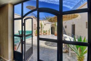 阿加迪尔Riad Amazine - Piscine - Rooftop - 6 or 7 Px的透过玻璃门欣赏庭院的景色