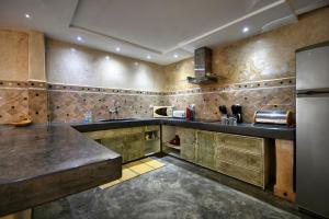 阿加迪尔Riad Amazine - Piscine - Rooftop - 6 or 7 Px的一个带木制橱柜和冰箱的大厨房