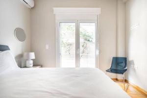 雅典Flisvos Marina refurbished apartment的白色的卧室设有一张大床和一个窗户