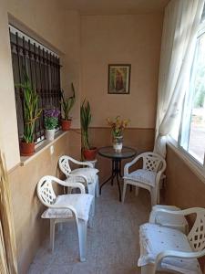 蓬塔翁布里亚La casa de Lola的一间设有白色椅子、桌子和窗户的房间