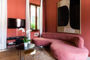 威尼斯Cà Regina Panada - passion on the Canal的客厅配有粉红色的沙发和桌子