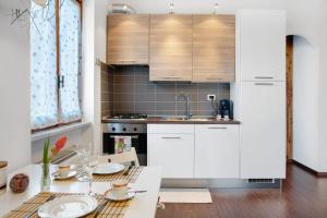 Roccaforte MondovìLurisia的厨房配有白色橱柜和一张带盘子的桌子