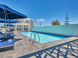 曼哲拉斯贝尔曼德拉酒店的一座游泳池旁设有两把蓝色椅子