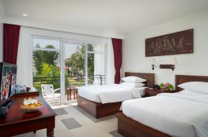 暹粒Sala Siem Reap Hotel的酒店客房设有两张床和一个阳台。