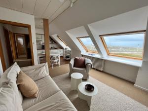 诺德奈Haus Janus 3 - Wohnung 4的带沙发和椅子的客厅以及2扇窗户。