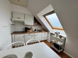 诺德奈Haus Janus 3 - Wohnung 4的厨房配有桌椅和窗户。