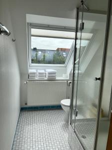 诺德奈Haus Janus 3 - Wohnung 4的带淋浴的浴室和带窗户的卫生间