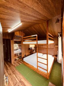 奈尼塔尔The Cocoon Camps & nature Resorts的木制客房内的一间带双层床的卧室