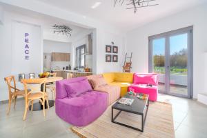 特劳洛斯Mythos Luxury Villa-Skiathos的客厅配有紫色沙发和桌子