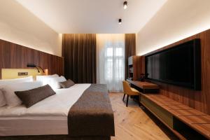 多布尔纳Hotel Švicarija - Terme Dobrna的一间酒店客房,配有一张大床和一台平面电视
