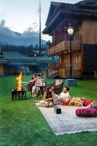 古尔马尔格凯伯尔喜马拉雅Spa度假酒店的一群人坐在火旁的草地上