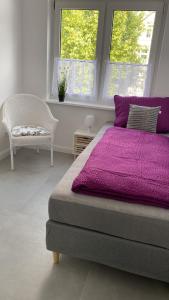 桑德Villa Mariensiel的一间卧室配有一张紫色的床和一把椅子