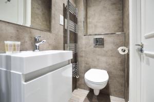 伦敦Woodview Serviced Apartments by Concept Apartments的浴室配有白色水槽和卫生间。