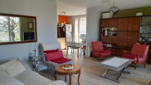 普瓦捷La terrasse的客厅配有红色椅子和桌子
