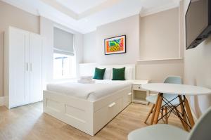 伦敦Woodview Serviced Apartments by Concept Apartments的白色卧室配有床和桌子