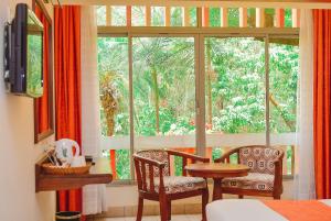 内罗毕Hotel Boulevard Nairobi, City Centre CBD的一间设有两把椅子、一张桌子和一个窗户的房间