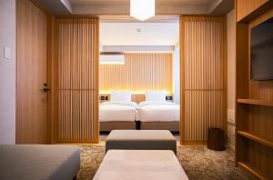 京都Miru Kyoto Gion的一间酒店客房,设有两张床和电视