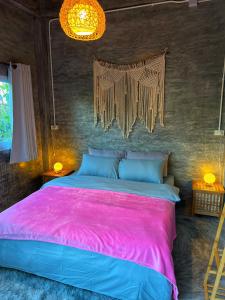 涛岛Wonderland Jungle Hostel的一间卧室配有一张带粉色毯子的大床