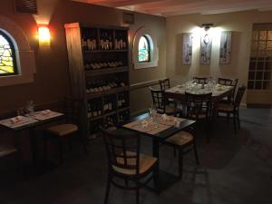 La Chapelle-Caro乐皮特凯瑞奎尔酒店的用餐室配有桌椅和葡萄酒瓶