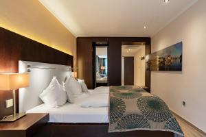 帕绍帕骚市公寓酒店的卧室配有白色大床和灯