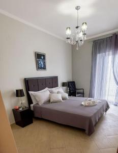 普雷韦扎Villa Archontia Family House!!!的一间卧室配有一张大床和一个吊灯。