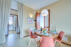 马斯诺维斯康蒂La Perla Bianca Lake View - Happy Rentals的一间带桌子和粉红色椅子的用餐室