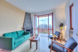 马斯诺维斯康蒂La Perla Bianca Lake View - Happy Rentals的客厅设有绿色沙发和壁炉
