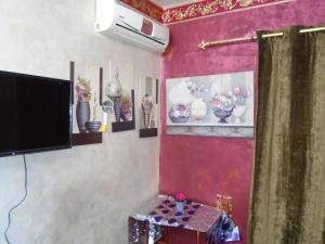 开罗City Hostel的客厅配有电视,墙上挂着鲜花