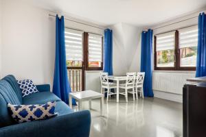 布科维纳-塔钱斯卡Apartamenty Wierchówka的客厅配有蓝色窗帘和桌椅