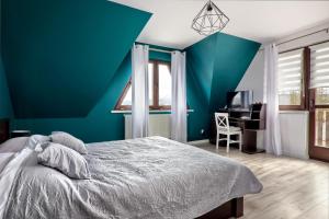 布科维纳-塔钱斯卡Apartamenty Wierchówka的蓝色卧室配有一张床和一张书桌